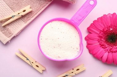 Çamaşır deterjanı, Gerbera çiçeği ve pembe arka planda mandallar.