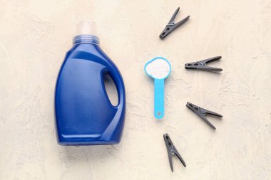 Çamaşır deterjanı ve çamaşır mandalları grunge bej arka planda