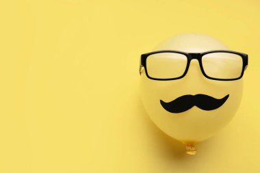 Kağıt bıyıklı balon ve arka planda gözlük.