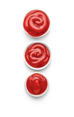 Beyaz arka planda izole edilmiş lezzetli ketçap kaseleri.