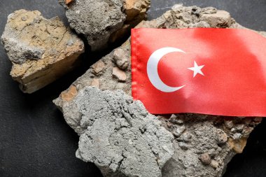 Koyu arkaplanda Türk bayrağı olan taş döküntüleri, yakın plan. Türkiye deprem kavramı