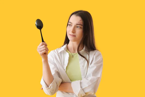 Young Woman Black Spoon Yellow Background — Stock Photo, Image