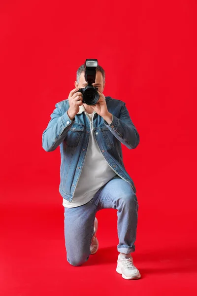 Rijpere Fotograaf Met Professionele Camera Rode Achtergrond — Stockfoto