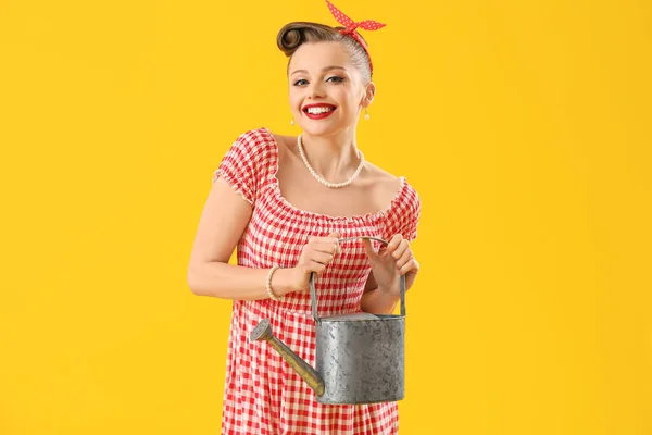 若いですピンアップ女性で散水缶上の黄色の背景 — ストック写真