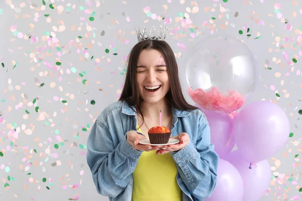 快乐的年轻女人 带着松饼在灰色背景下庆祝生日 — 图库照片