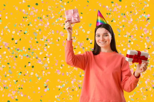 幸せな若いです女性とともに誕生日ギフト上の黄色の背景 — ストック写真