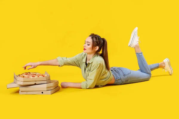 Νεαρή Γυναίκα Χαρτονένια Κουτιά Νόστιμης Πίτσας Ξαπλωμένη Κίτρινο Φόντο — Φωτογραφία Αρχείου