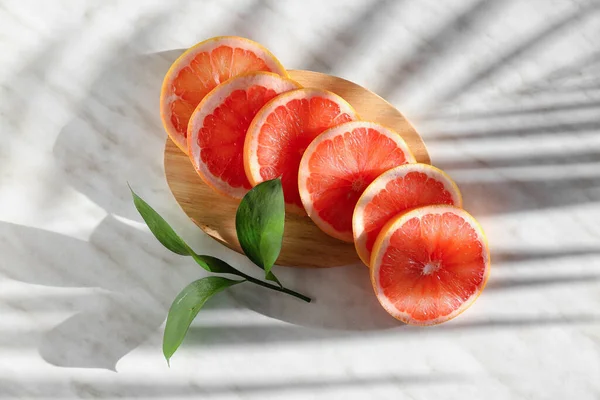 Wooden Board Slices Ripe Grapefruit Plant Branch Light Background — Stock Photo, Image