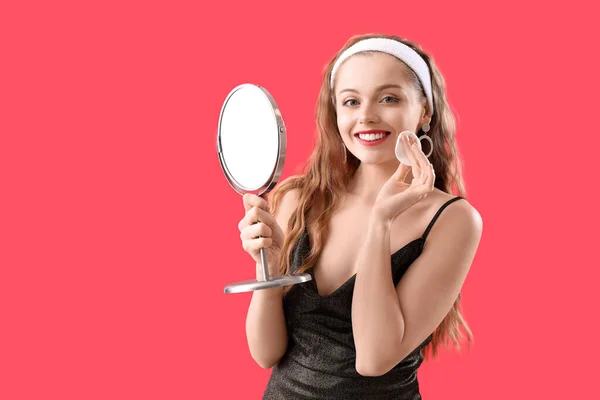 Jovem Com Espelho Removendo Maquiagem Fundo Vermelho — Fotografia de Stock