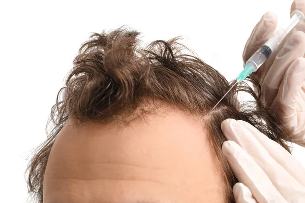 stock image Young man receiving injection for hair growth on white background, closeup