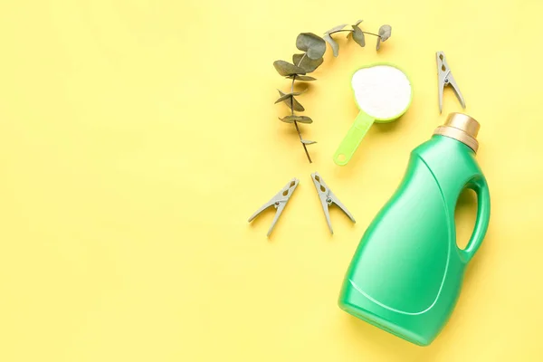 Stock image Laundry detergents, eucalyptus branch and clothespins on yellow background