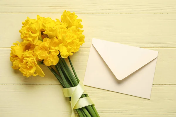 Mooie Narcissen Bloemen Met Geel Lint Envelop Lichte Houten Achtergrond — Stockfoto