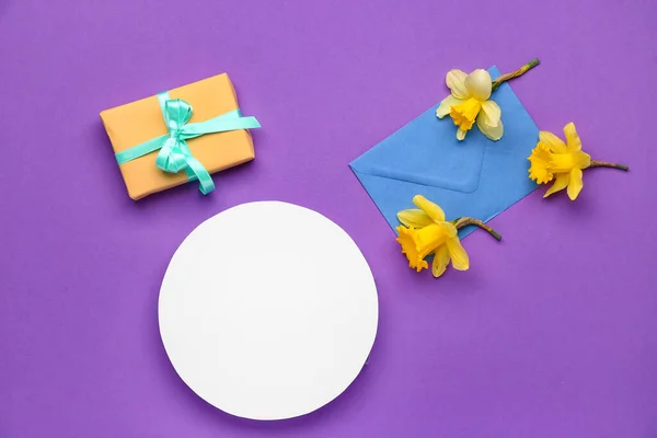 stock image Beautiful narcissus, gift box, envelope and round blank card on color background