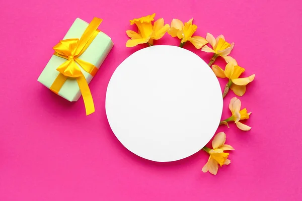 stock image Beautiful narcissus, gift box and round blank card on color background