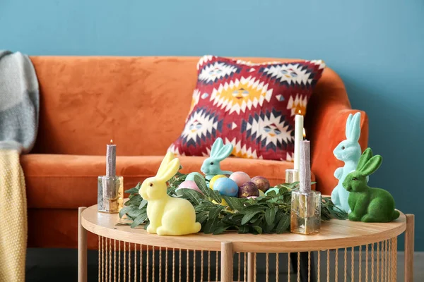 Coffee table with bunnies, candles, wreath and Easter eggs in living room