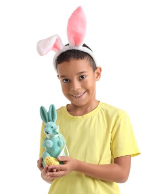 Beyaz arka planda Paskalya yumurtası ve tavşanı olan küçük Afro-Amerikalı çocuk.