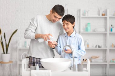 Morning of father and his little son shaving in bathroom