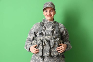 Yeşil arka planda askeri üniformalı kadın asker.