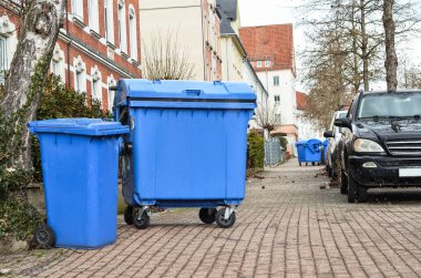 Mavi çöp konteynırlarıyla şehir caddesi manzarası