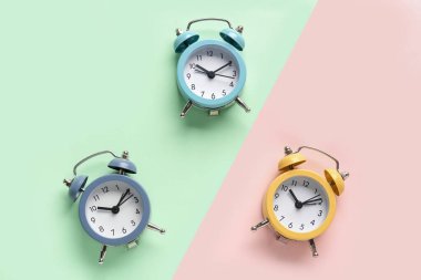 Renkli arkaplanda üç alarm saati