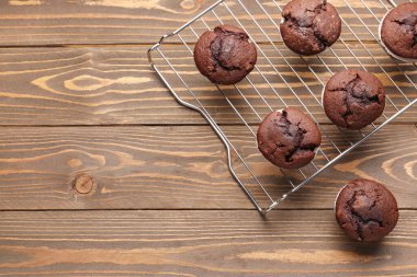 Ahşap arka planda lezzetli çikolatalı kekleri olan ızgara, yakın plan.