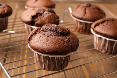 Ahşap arka planda lezzetli çikolatalı kekleri olan ızgara, yakın plan.