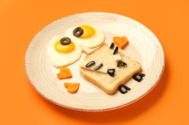 Turuncu arka planda komik çocuk kahvaltısı tabağı.