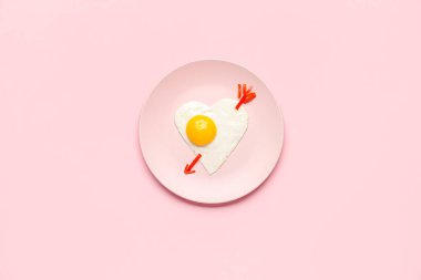 Pembe arka planda şirin çocuk kahvaltısı tabağı.