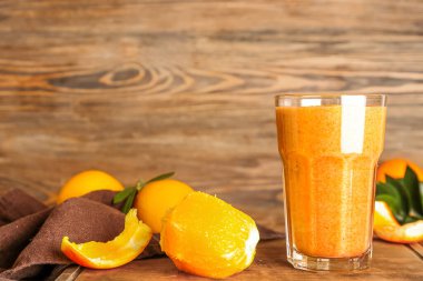 Sağlıklı meyve püresi ve ahşap masada soyulmuş portakal.