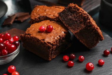 Siyah arka planda lezzetli çikolatalı brownie parçaları olan bir pano.