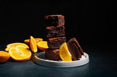 Siyah arka planda lezzetli çikolatalı browni tabağı.