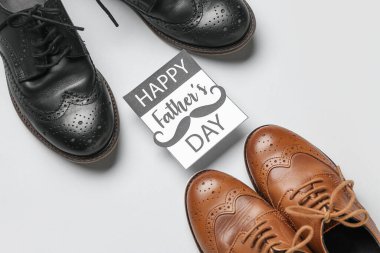 Beyaz arka planda şık erkek ayakkabıları ve yazılı kart Mutlu Babalar Günü