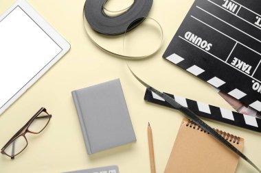 Bej arka planda film, film makarası ve tablet bilgisayarlı defterler