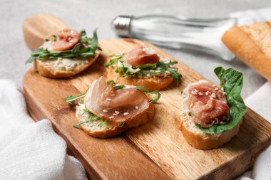 Ispanaklı lezzetli jamon bruschettalar ve grunge arkaplanda roka.