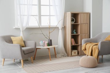 Paskalya dekoru ve koltukları olan oturma odasının içinde.