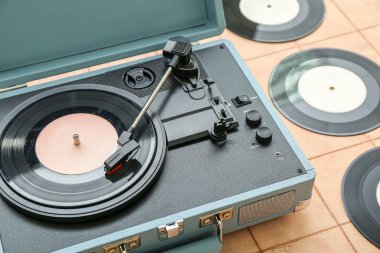 Bej kaplama üzerinde vinil diskleri olan kayıt çalar, yakın plan