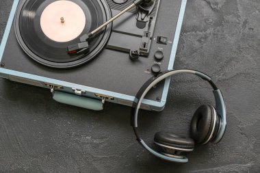 Koyu arkaplanda vinil diski ve kulaklığı olan kayıt çalar