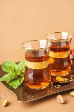 Bej arkaplanda bir bardak Türk çayı tepsisi