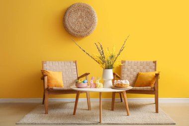 Paskalya kutlaması için dekore edilmiş oturma odasının içinde koltuklar ve masa var.