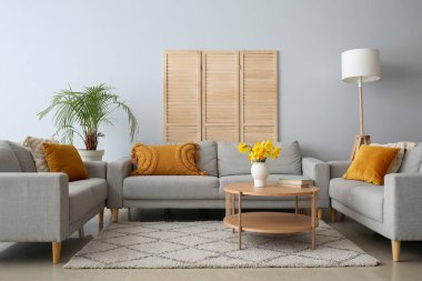 Oturma odasında rahat koltuklar ve kahve masası var.