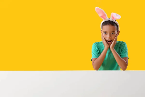 色の背景にウサギの耳の小さなアフリカ系アメリカ人の少年を驚かせた イースターのお祝い — ストック写真