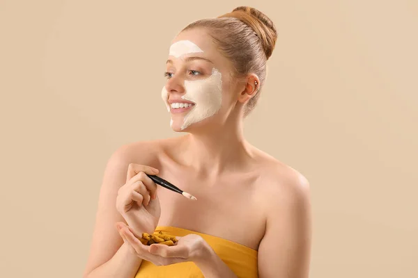 Young Woman Applied Turmeric Mask Brush Roots Beige Background Closeup — Stok Foto