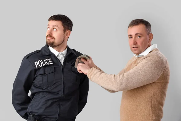 Mature Man Giving Bribe Policeman Grey Background — Stock Photo, Image