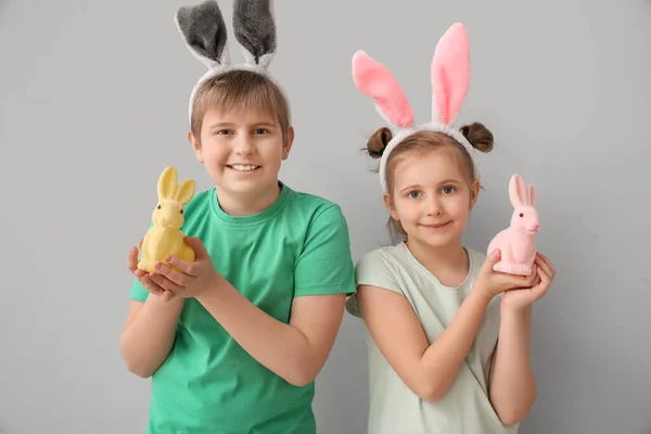 灰色の背景にイースターウサギとウサギの耳の小さな子供たち — ストック写真