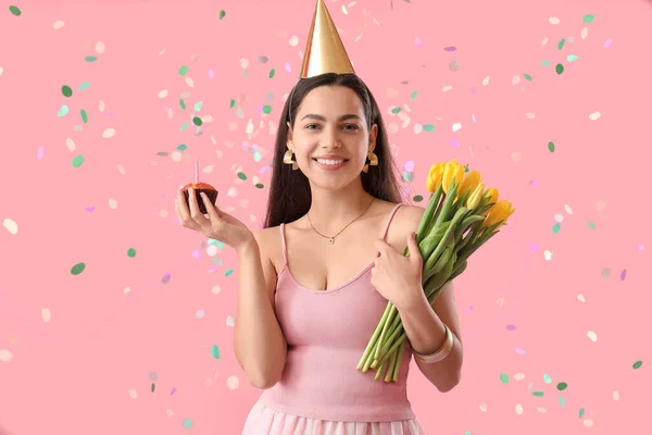 Glad Ung Kvinna Med Födelsedagsmuffins Och Tulpaner Rosa Bakgrund — Stockfoto
