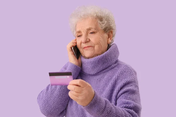 Senior Woman Credit Card Talking Mobile Phone Lilac Background Closeup — Stock Photo, Image