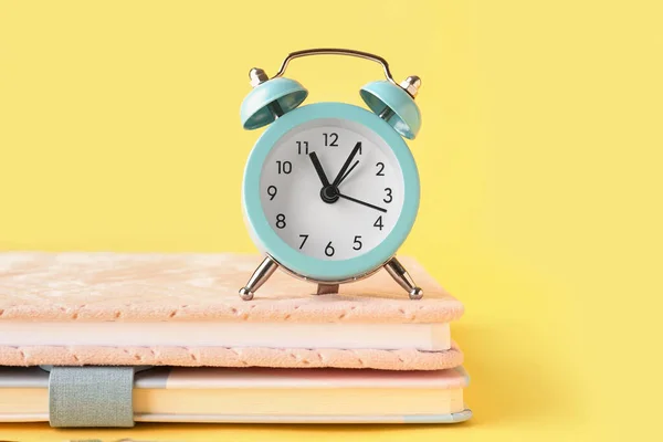 Notebooks Alarm Clock Yellow Background — Stock Photo, Image