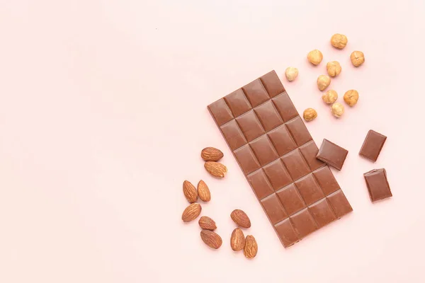 Komposition Mit Schmackhafter Schokolade Und Nüssen Auf Farbigem Hintergrund — Stockfoto