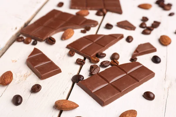 Leckere Schokoladenstücke Mandeln Und Kaffeebohnen Auf Hellem Holzgrund Nahaufnahme — Stockfoto