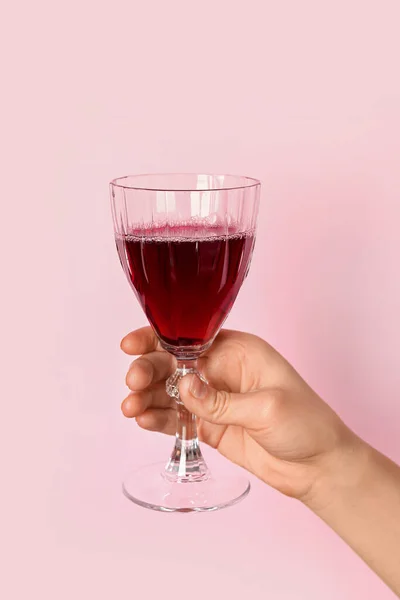 Vrouwelijke Hand Houden Glas Rode Wijn Roze Achtergrond — Stockfoto